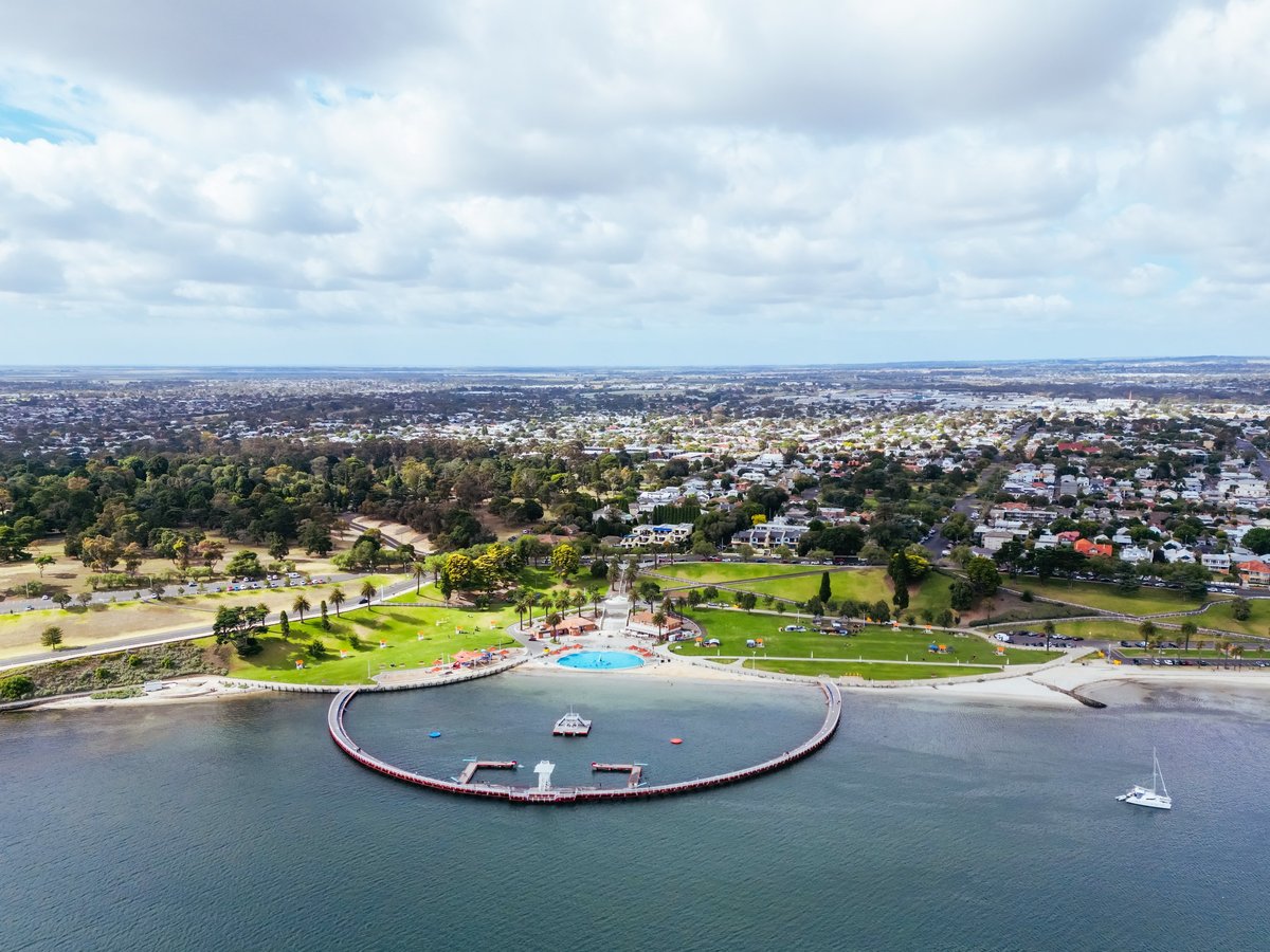 Aerial views from Port Phillip Bay towards the Geelong CBD and Eastern Beach Children's Pool on a warm summer morning