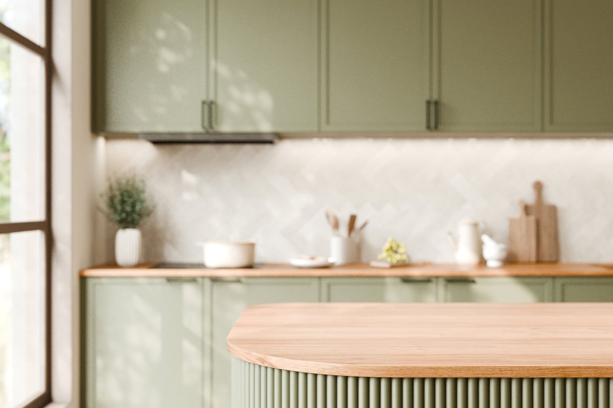 A modern Geelong kitchen renovation with green cabinetry and a wooden countertop