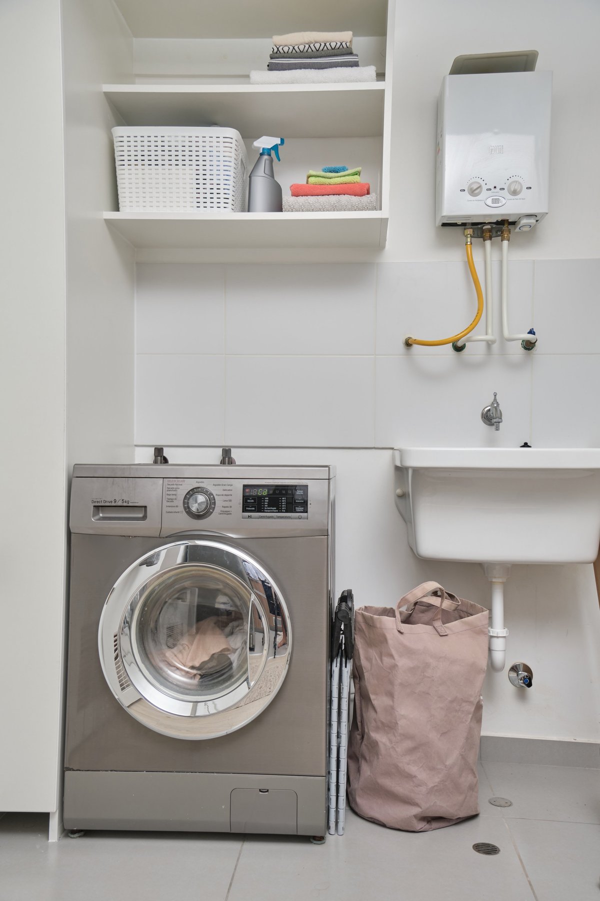 A tidy Geelong laundry renovation with washing machine, sink and built in shelving